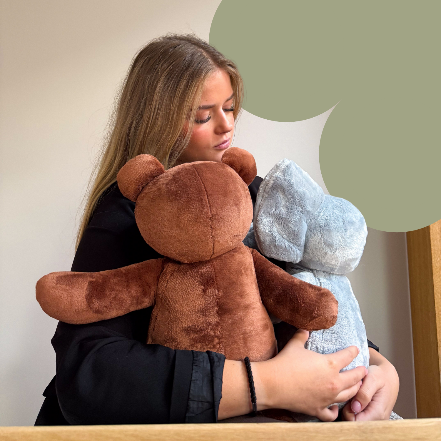 Vrouw houdt Hugsback verzwaarde knuffelbeer en olifant vast, straalt rust en comfort uit