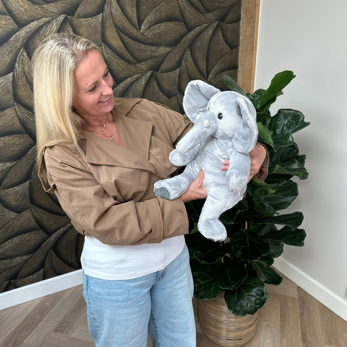 Vrouw thuis houdt de Hugsback Olifant vast