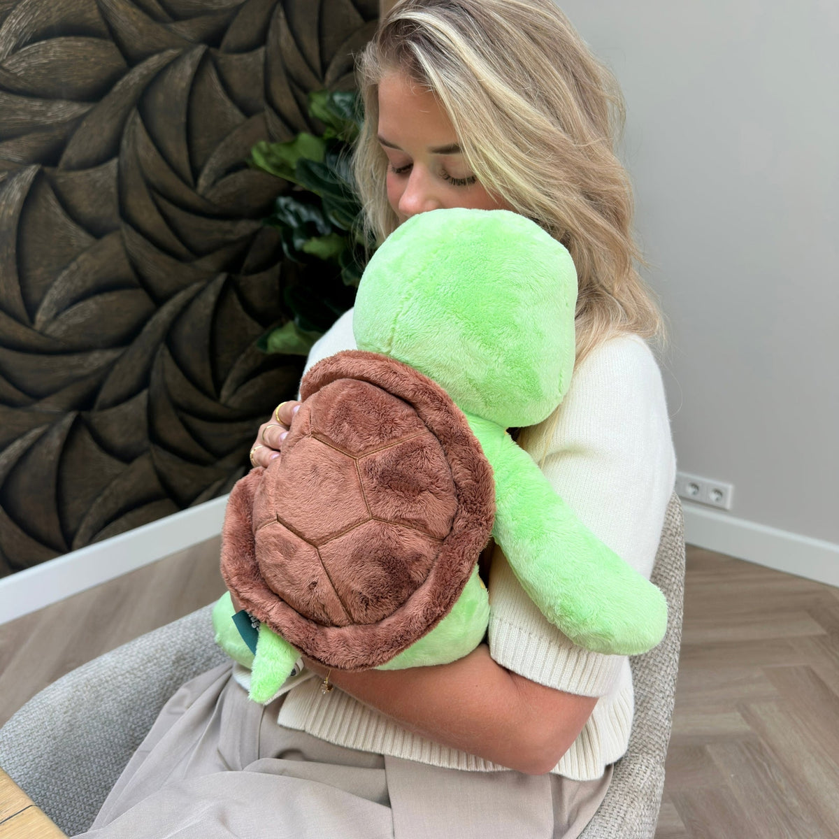 Frau umarmt das grüne Hugsback Gewichtskuscheltier Schildkröte fest