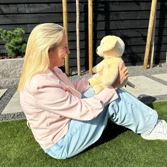 Femme avec la peluche lestée chien Hugsback beige dans le jardin