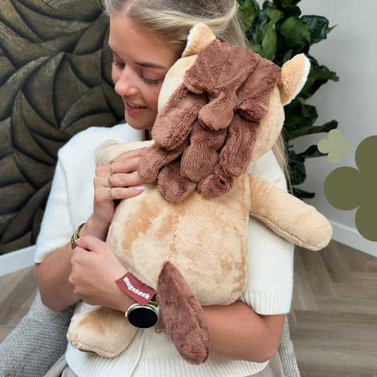 Jonge vrouw knuffelt de bruine Hugsback verzwaringsknuffel paard