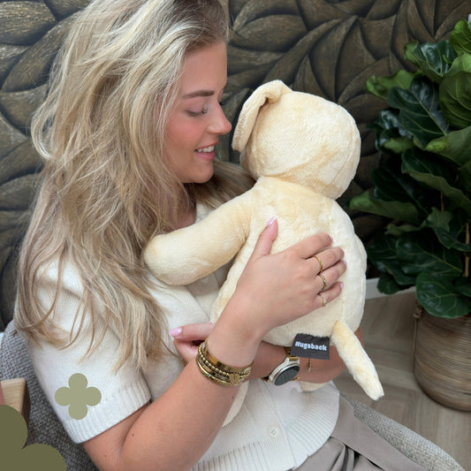 Jonge vrouw knuffelt de beige Hugsback verzwaringsknuffel hond