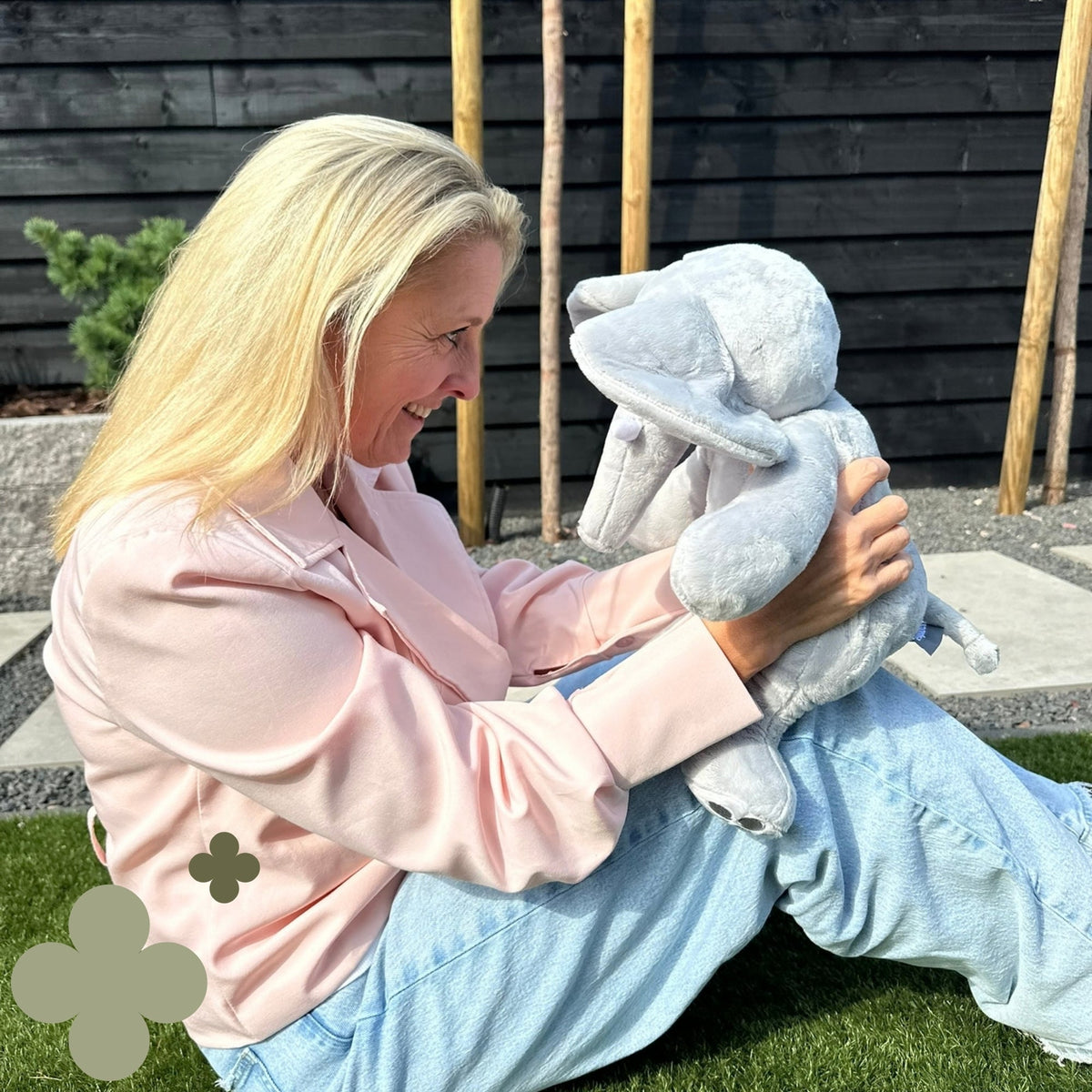 Vrouw in de tuin houdt de Hugsback Olifant vast