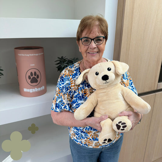 Ældre kvinde med den beige Hugsback-hund ved det lyserøde gaverør