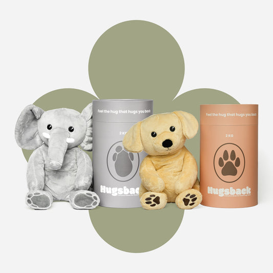 De Hugsback verzwaringsknuffels olifant en hond met hun grijze en zalmroze cadeaukokers