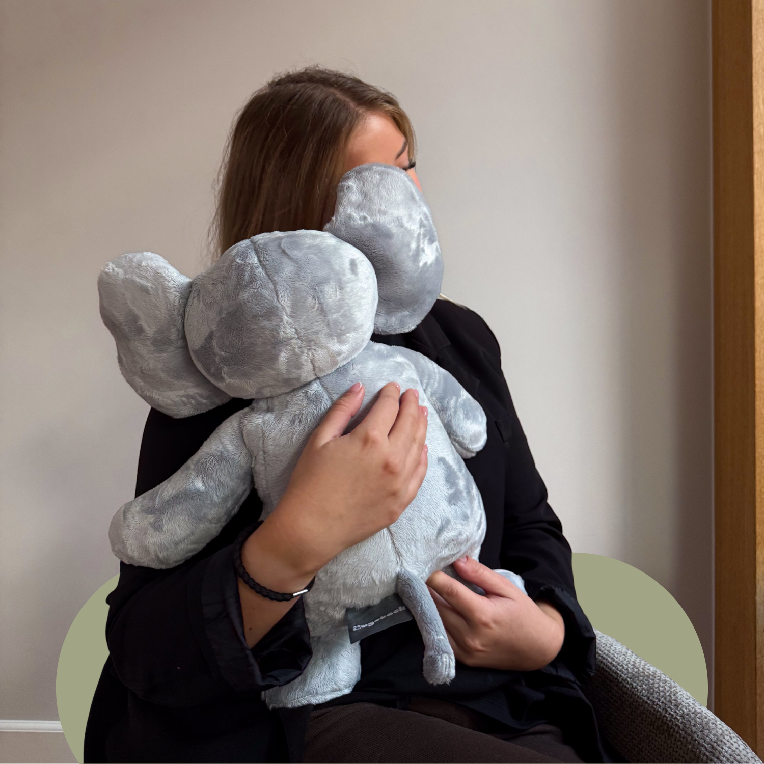 Vrouw knuffelt een Hugsback verzwaarde knuffel olifant voor comfort en rustmomenten
