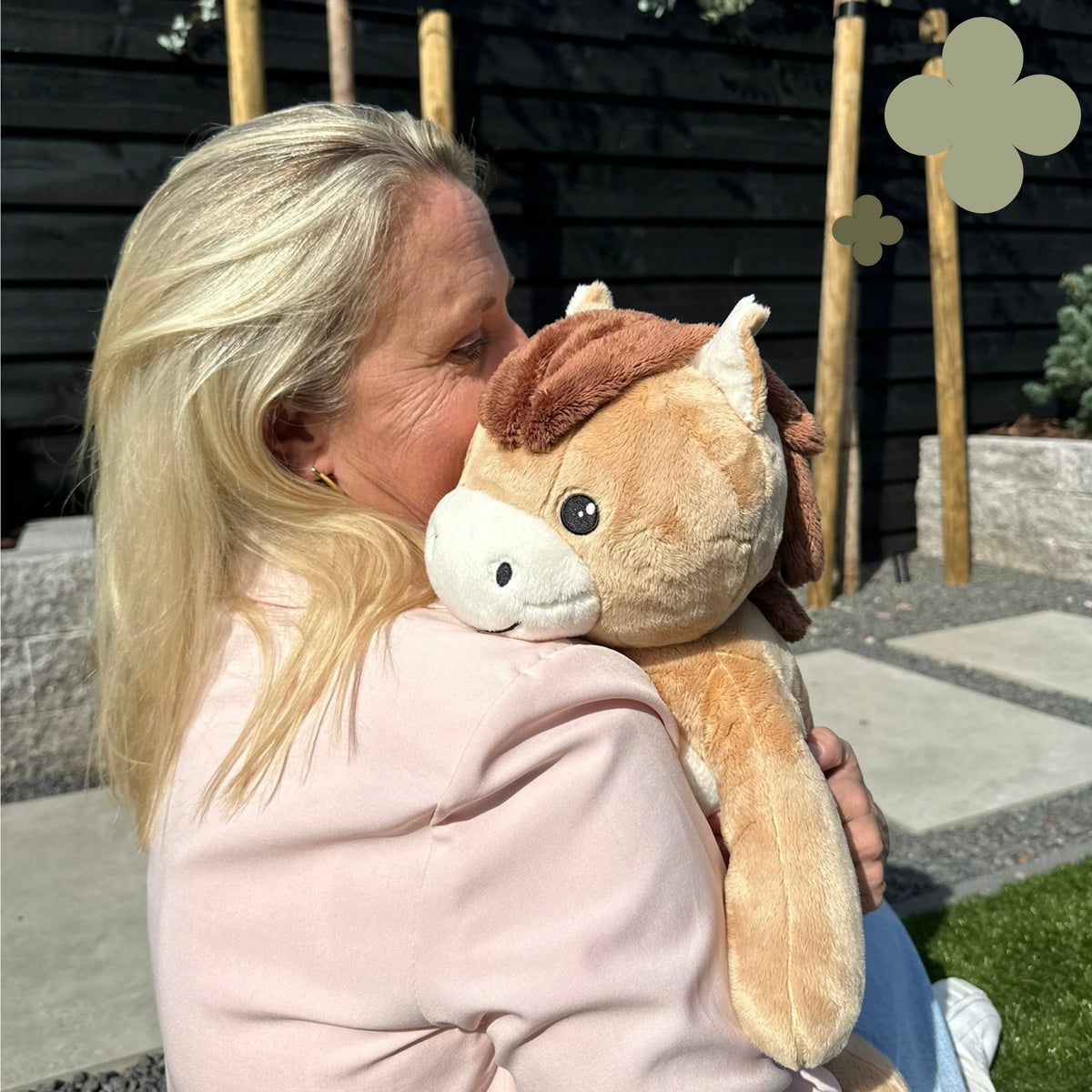 Femme qui câline la peluche lestée cheval marron à l'extérieur
