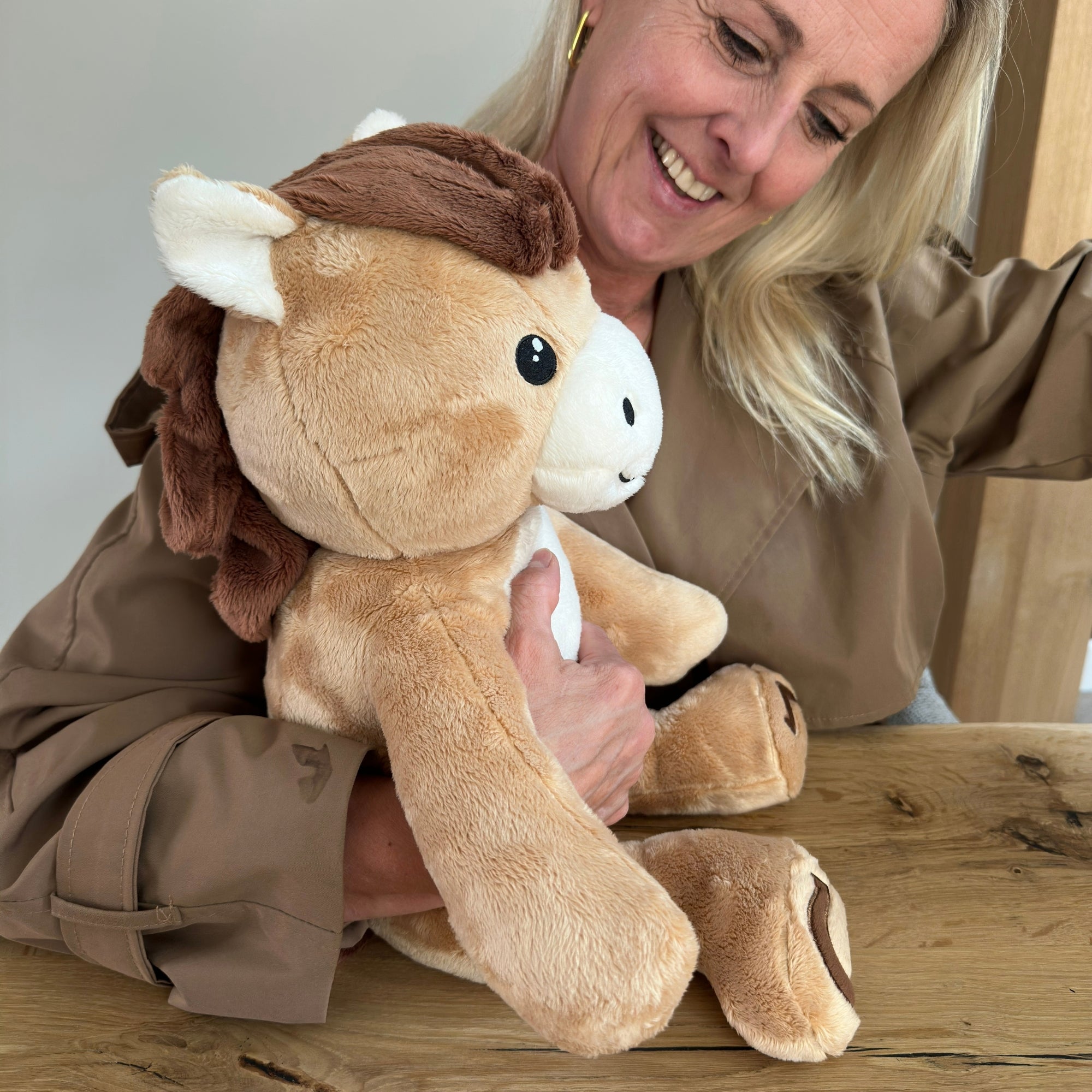 Lachende vrouw met de bruine verzwaringsknuffel paard