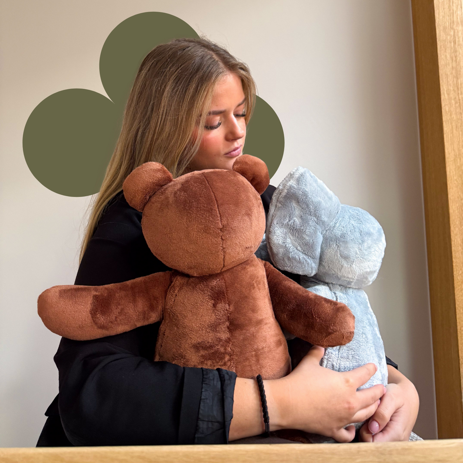 Een vrouw houdt twee Hugsback-verzwaringsknuffels stevig vast en ervaart directe rust, warme druk en geborgenheid dankzij het zachte 2 kg design.