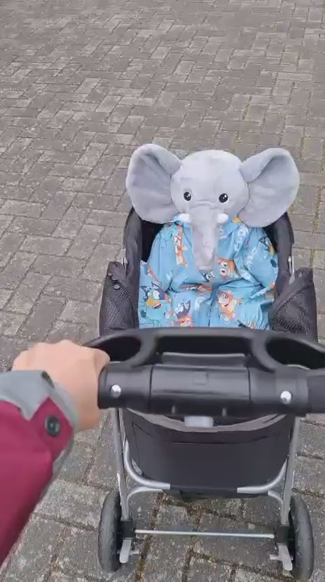 Video van de grijze verzwaringsknuffel olifant in een pyjama in een kinderwagen buiten